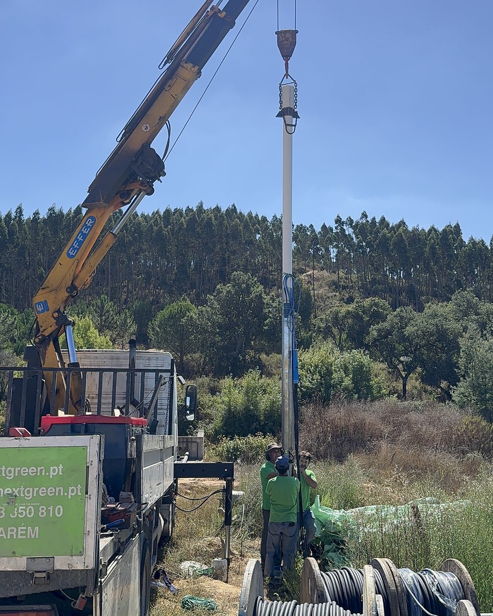 Coluna de furo suspensa pela grua, pronta a descer